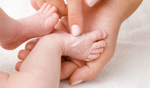 Female,Hand,Holding,Newborn,Leg,On,White,Towel.,Mother,Carefully