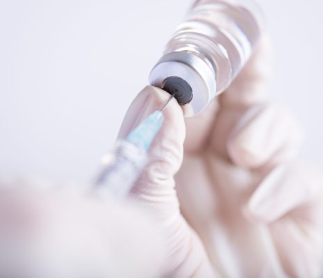 Female doctor hands holding syringe and vaccine. Healthcare And Medical concept.